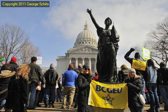 The protest surrounds the 'forward' statue. This 'forward' statue is a symbol of the state of Wisconsin's forwardness.